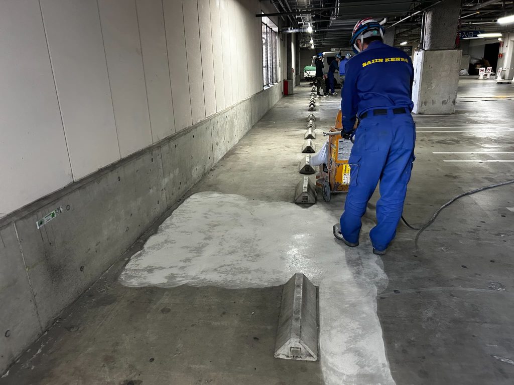 京都府京都市の商業施設駐車場。劣化したコンクリート床を研磨機で磨いている施工中の様子。