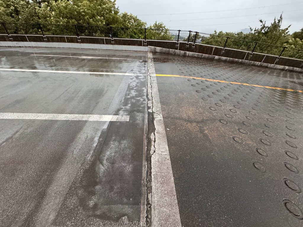 東京都町田市にある商業施設の駐車場。駐車場とスロープの境目が劣化により亀裂が入っている様子。