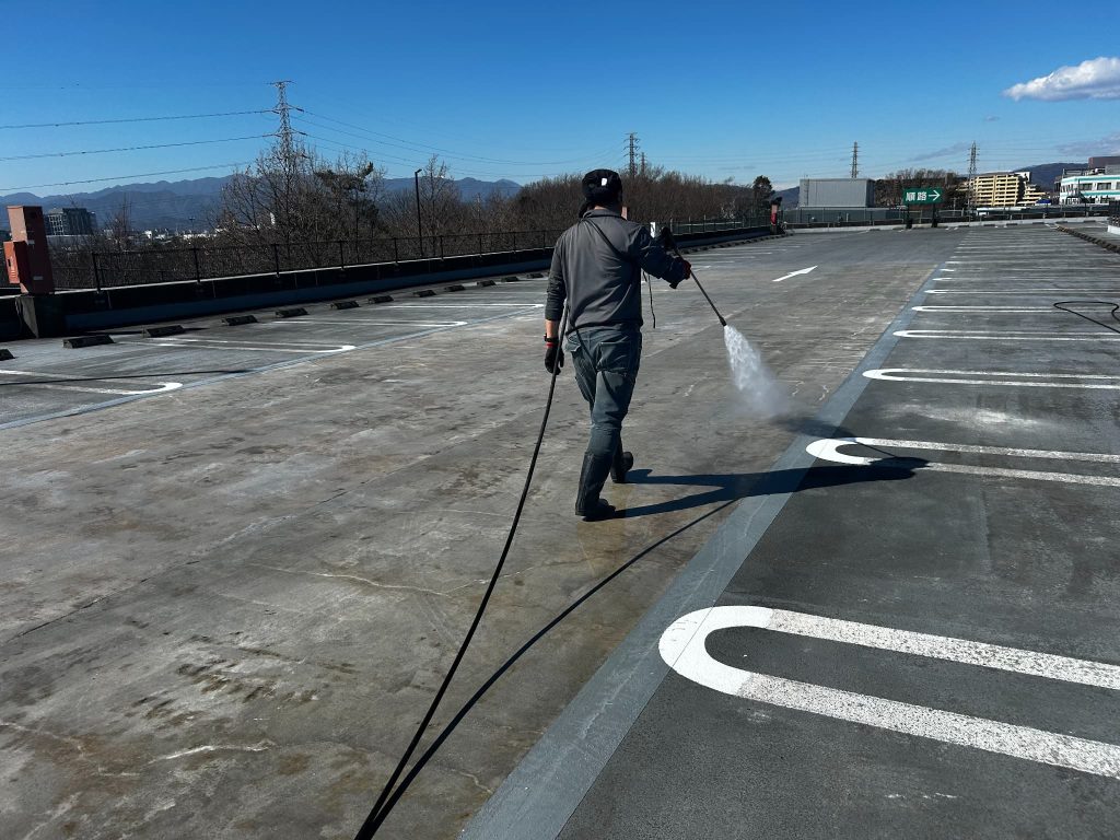 東京都町田市にある商業施設の駐車場。シリカテックの残材を高圧洗浄機で除去している様子。