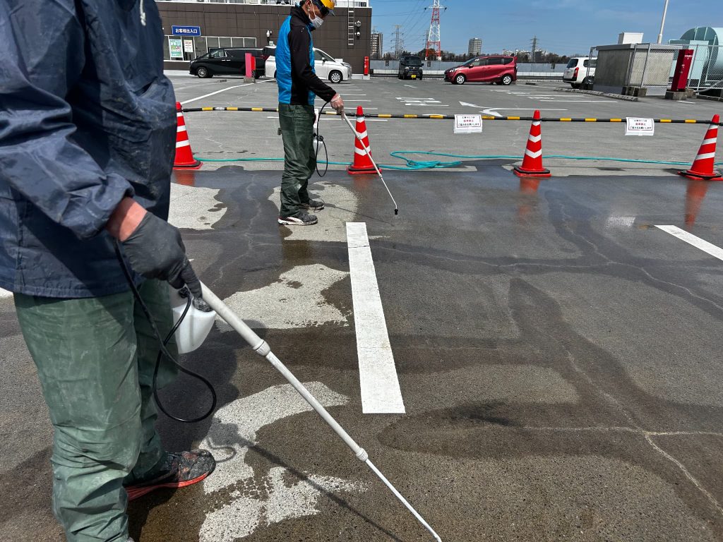 東京都府中市のショッピングモールの立体駐車場。屋上の補修部分、全面にシリカテックを散布している様子。