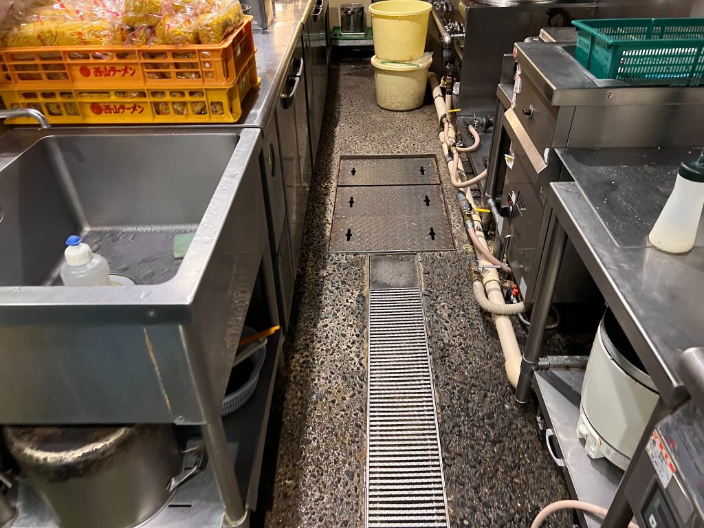 飲食店の厨房の写真。グレーチングより漏水発生中。